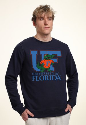 Marineblaue Sweatshirt mit dem Text der University of Florida und einem Gator-Maskottchen in Orange und Grün. Weicher Stoff mit Rundhalsausschnitt und langen Ärmeln.
