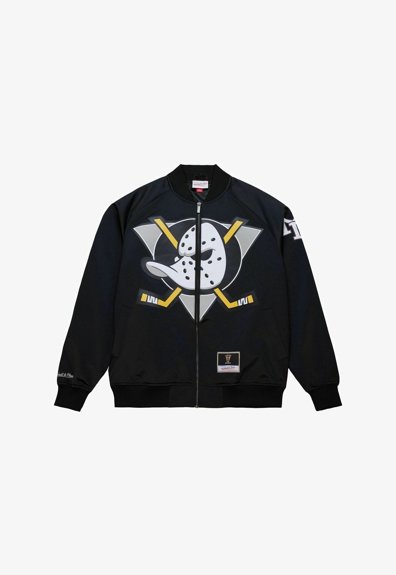Veste bomber noire présentant un graphique marquant d'un canard avec un bâton de hockey, des accents jaunes et un patch de marque sur le bas de l'ourlet.