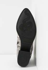 Semelle d'une chaussure à bout pointu avec un motif de serpent, taille 37, logo « bugatti » sur la semelle et une surface supérieure en cuir effet peau de serpent texturé visible.