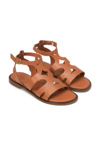 Brown leather sandals with cut-out star shapes, adjustable ankle strap, flat sole, and smooth texture.