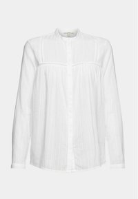 Blouse blanche à manches longues avec une texture verticale subtile, col rond, fermeture boutonnée sur le devant et délicats détails de couture horizontale sur la poitrine.