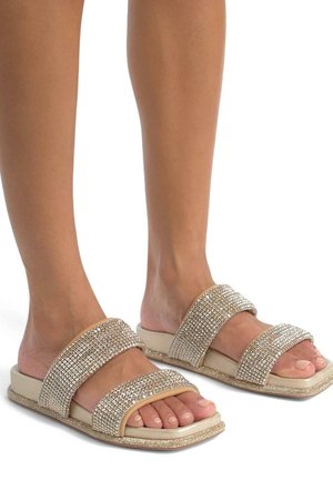 I sandali a infradito in tono dorato presentano due ampie cinghie decorate con strass, una soletta imbottita e un fondo texturizzato per grip e comfort.