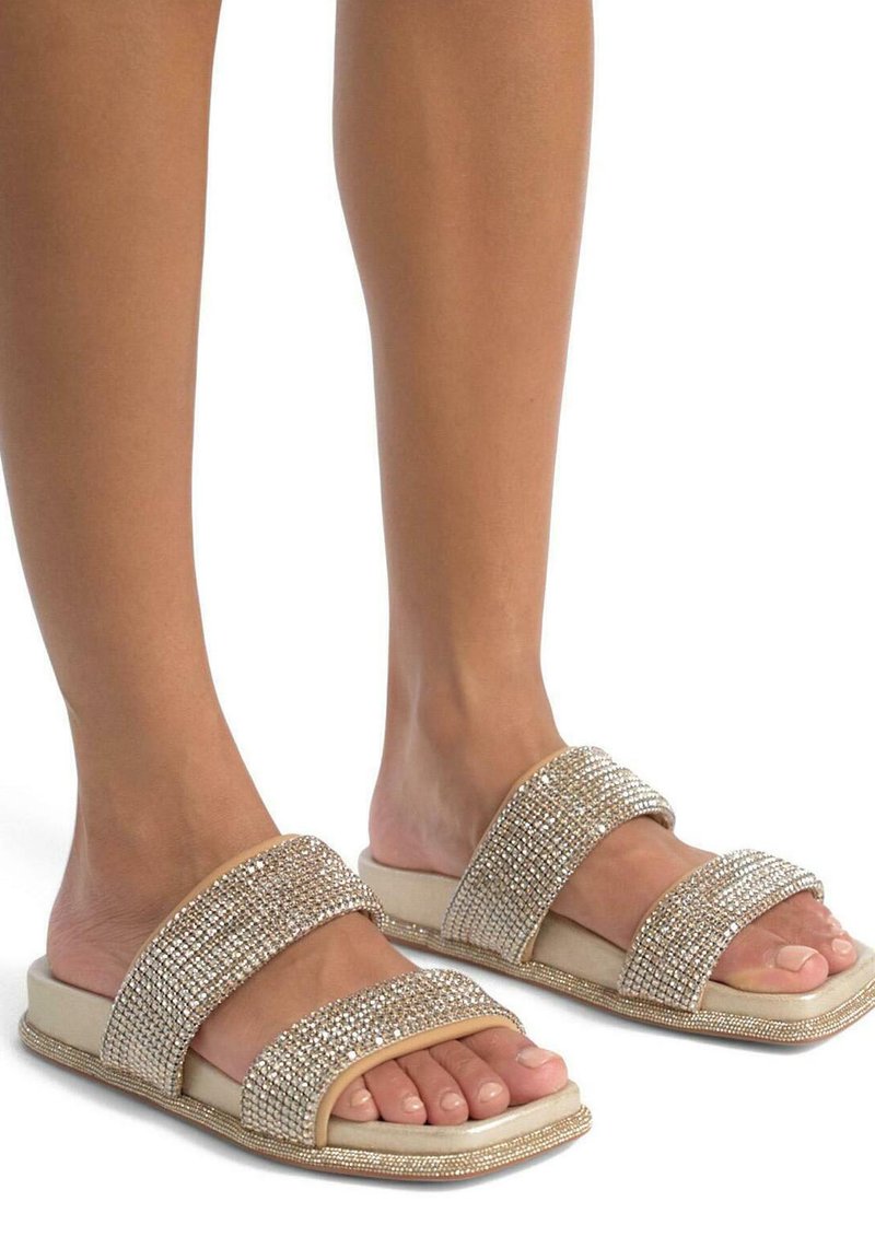 I sandali a infradito in tono dorato presentano due ampie cinghie decorate con strass, una soletta imbottita e un fondo texturizzato per grip e comfort.