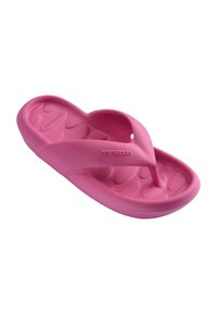 Sandale tong en mousse rose vif avec semelle texturée et larges brides portant le logo "havaianas" sur un côté.