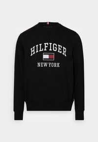 Black sweatshirt with a crew neckline, featuring white embroidered text "HILFIGER NEW YORK" and a red and blue logo patch. Smooth fabric texture.