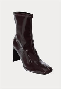Burgundin väriset nilkk bootsit kiiltävällä pinnalla, neliön muotoinen kärki ja korkea lohkokorko. Ominaisuudet: virtaviivainen muotoilu, jossa on minimaalista ompelutyyliä.