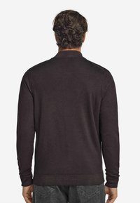 Mörkbrun långärmad polo stickad tröja med mjuk textur, ribbade manschetter och klassisk krage, sedd bakifrån.