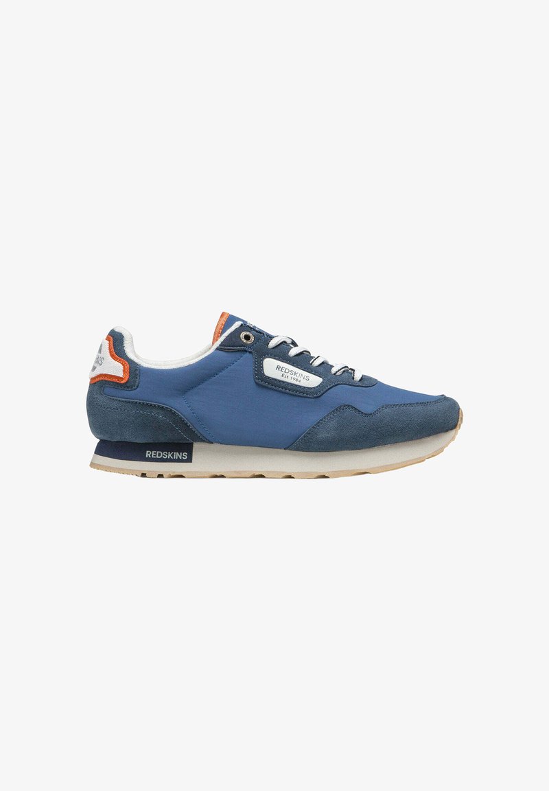 Basket bleu et bleu marine avec lacets blancs, détails orange, semelle en caoutchouc et marque « Redskins » sur le côté et le talon.