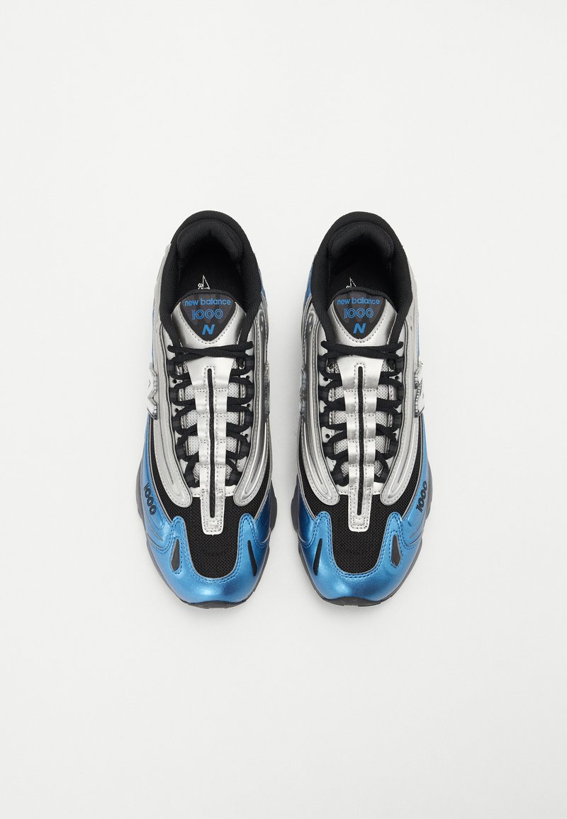 Schwarze und silberne Sportschuhe mit blauen Akzenten, ausgestattet mit einem Mesh-Obermaterial, strukturierten Überzügen und auffälligen Schnürsenkeln. Modell "1000" sichtbar.