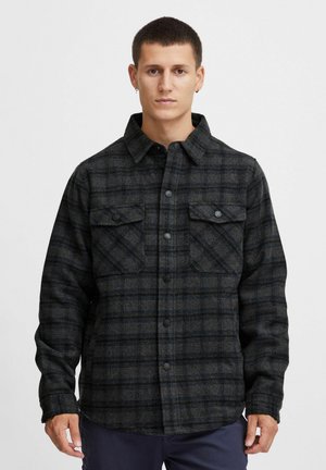 Flannel patterned shirt in dark gray with blue accents, featuring a button front, two chest pockets, and a collared neckline. Structured fit.