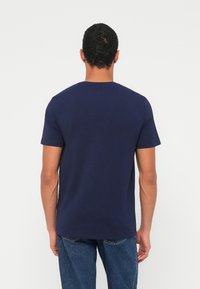 Navy zila īsroku t-krekls ar apaļu kaklu, izgatavots no mīkstas auduma, taisna piegriezuma un vienkārša dizaina bez rotājumiem.