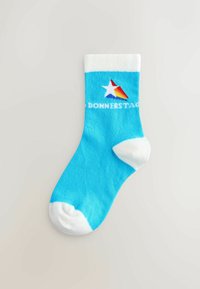 Calzino di cotone blu con risvolto e punta bianchi, caratterizzato da un logo a stella multicolore e la scritta "DONNERSTAG" in bianco.