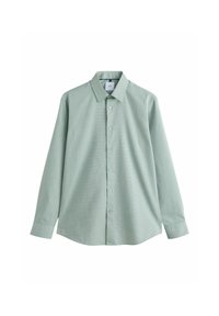 Chemise à manches longues vert clair avec col pointu, tissu texturé et poignets boutonnés, étalée à plat sur un fond blanc.