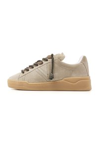 Beige suede sneakers with a low profile, textured rubber sole, and braided laces featuring metallic accents. White inner lining.