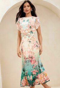 Bloemen maxi-jurk met pastelkleuren, korte puffmouwen en een ombre-effect van crème naar teal, afgewerkt met gedetailleerde botanische patronen.