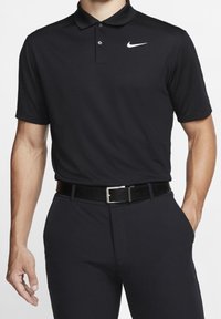 Black polo shirt made of smooth fabric, featuring a collar, three buttons, and a white Nike logo on the left chest. Worn with a black belt.