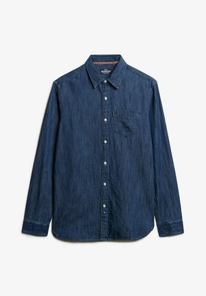 Camisa de denim en azul oscuro con mangas largas, cierre de botones, cuello puntiagudo y un bolsillo en el pecho. Textura suave con un patrón sutil.