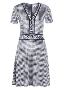 Knie-lange jurk in marineblauw en witte houndstoothpatroon, met een V-halslijn en korte mouwen, voorzien van een contrasterende tailleband.