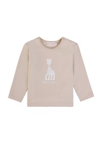 Camicia beige in cotone a maniche lunghe con una silhouette bianca di una giraffa e il testo "SOPHIE LA GIRAFFE" sotto il design.