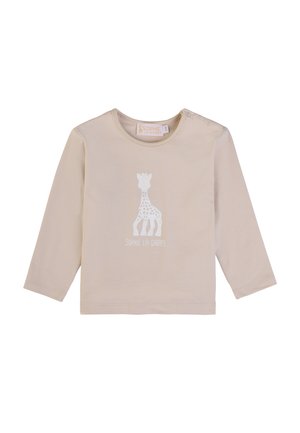 Beige Baumwollhemd mit langen Ärmeln, das eine weiße Silhouette einer Giraffe und den Text "SOPHIE LA GIRAFFE" unter dem Design zeigt.