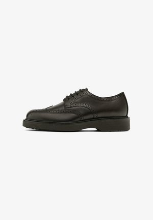 Schwarzer Lederschnürschuh mit Brogue-Details, rundlicher Zehenpartie und Gummisohle. Verfügt über Ziernähte entlang der Kanten.