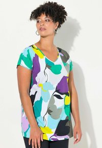 Top de manga corta con escote en V en tejido ligero. Presenta un gran patrón floral abstracto en tonos verde azulado, púrpura, amarillo y negro sobre un fondo blanco.
