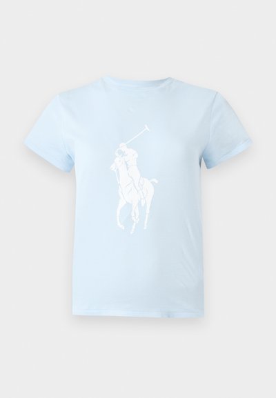 Φωτεινό μπλε T-shirt με λευκό γραφικό ενός παίκτη πόλο που ιππεύει ένα άλογο και κρατάει ένα ανασηκωμένο ρόπαλο μπροστά.