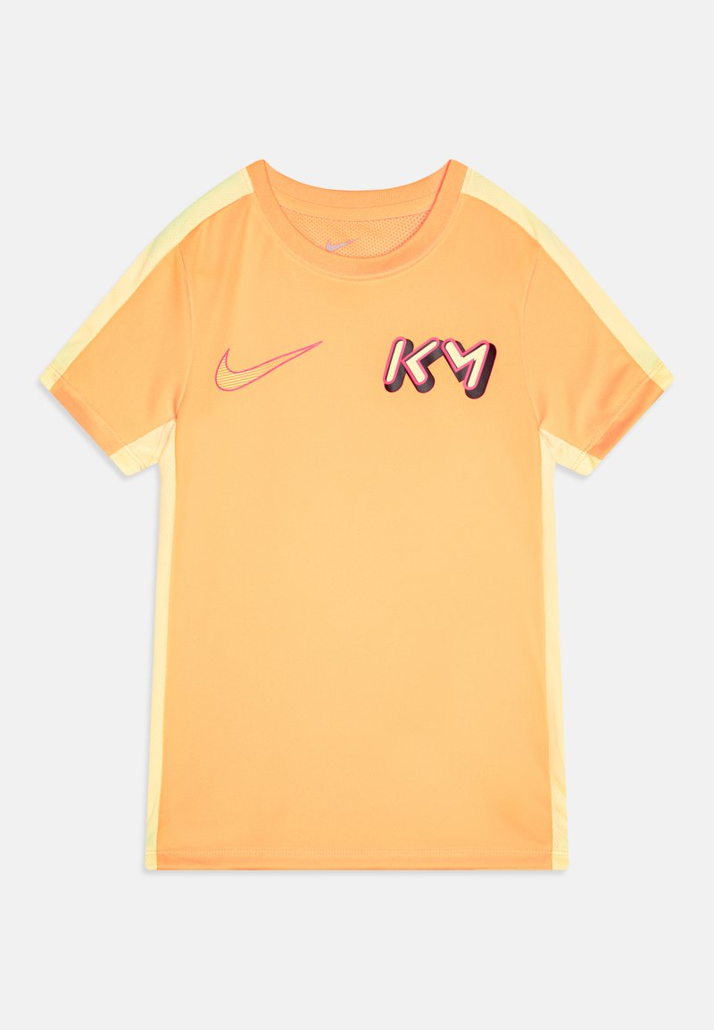 Oranžs sporta krekls ar īsām piedurknēm, dzelteniem akcentiem, Nike logotipu un uzrakstu "KY" biezā, stilizētā fontā priekšā. Audums ir gluds.