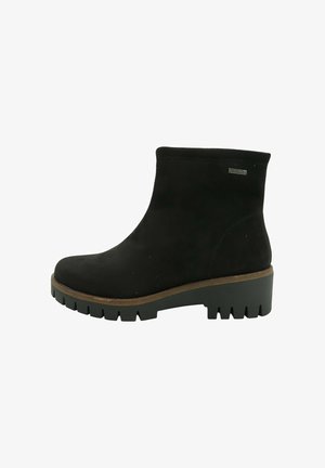 Bota negra impermeable hasta el tobillo con suela gruesa de tacos y tacón bajo tipo bloque, con una parte superior lisa y una pequeña etiqueta metálica impermeable.