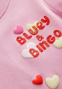Różowa bluza z napisem "Bluey & Bingo" w czerwonym, teksturowanym haftem, ozdobiona różnymi filcowymi sercami w kolorach różowym, czerwonym i kremowym.