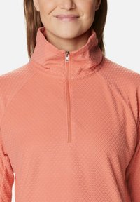 Pullover rosa chiaro con colletto a mezza zip, motivo testurizzato e maniche raglan, realizzato in tessuto morbido per il comfort.
