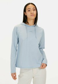 Lichtblauwe hoodie met lange mouwen en een zachte textuur, voorzien van een kangoeroezak en koordjes. De tekst op de voorkant luidt "MADE FOR DAILY ADVENTURES."