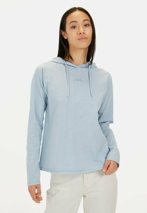 Hellblaue Kapuzenjacke mit langen Ärmeln und weicher Textur, ausgestattet mit einer Kängurutasche und Zugbändern. Der Text auf der Vorderseite lautet "FÜR TÄGLICHE ABENTEUER GEMACHT."