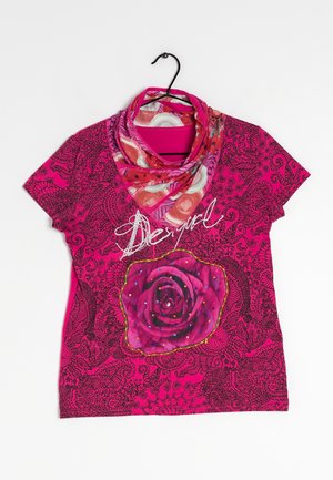 Felroze shirt met korte mouwen en zwarte, fijne bloemmotieven, grote roosafbeelding, tekst "Dear girl" en een multikleurige sjaal aan een zwarte hanger.