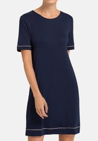 Abito blu navy realizzato in tessuto morbido, con maniche corte e bordi bianchi sui polsini e sull'orlo, e scollatura rotonda. Silhouette A-line semplice.