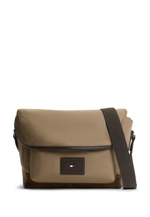 Hellbraune Umhängetasche mit dunkelbraunem verstellbarem Riemen und kleinem rechteckigem Logo-Patch auf der Vorderseite.