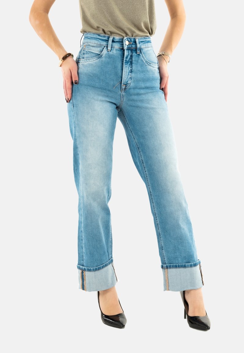 Jeans de tiro alto en un azul claro, con pierna recta y dobladillos vueltos. Tienen una textura de mezclilla suave y detalles de costura en contraste.