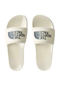 Sandalias blancas sin tiras con una amplia correa que presenta el logo de "THE NORTH FACE" en negro. Textura mate suave, forma redondeada, diseño minimalista.