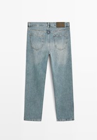 Niebieskie, jasne dżinsy o prostym kroju, z pięcioma kieszeniami, skórzaną łatą z tyłu oraz przetartą teksturą.