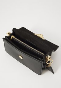 Black leather clutch bag with a textured finish, gold hardware, zippered compartment, and magnetic closure. Interior features suede lining.