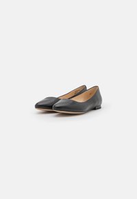 Ballerines en cuir noir avec un bout pointu et un design minimaliste. Elles présentent un petit talon et une texture lisse. Taille 37 indiquée à l'intérieur.
