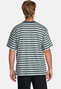 Randig t-shirt med korta ärmar i blågrönt, rosa och vitt. Har rund halsringning och lös passform med en etikett vid nedre sidan. Bomullsmaterial.