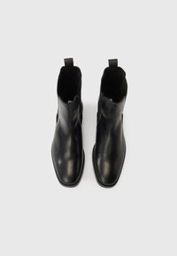 Černé kotníkové kožené boty s hladkým povrchem, zaoblenou špičkou, elastickými bočními panely a poutky pro snadné nazouvání.