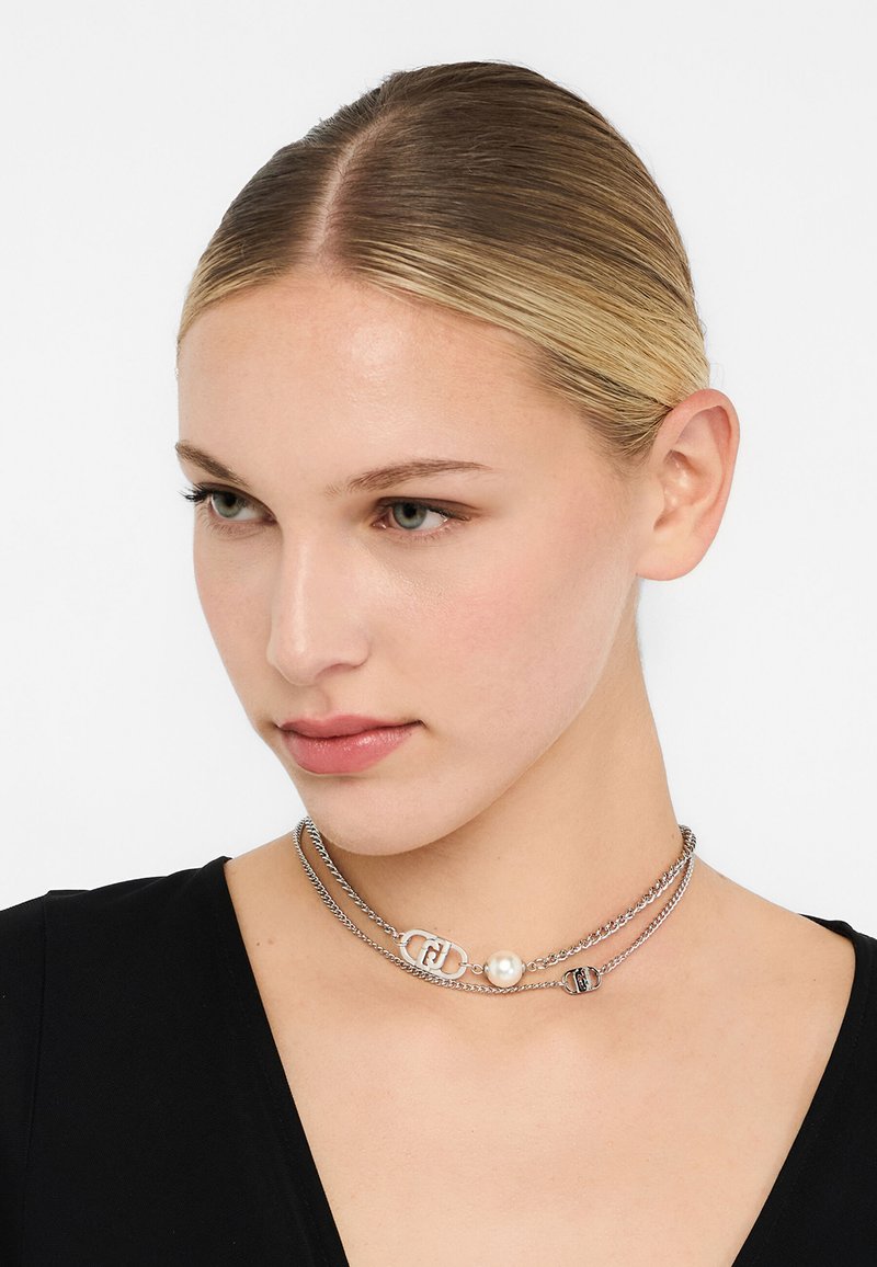Srebrny choker warstwowy z perłą, ogniwami łańcucha i detalami z logo. Gładka faktura i elegancki design, odpowiedni do różnych stylów.
