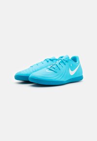 Scarpe sportive blu con una tomaia texturizzata, design curvo e logo swoosh bianco. Dotate di lacci e suola in gomma con trazione.