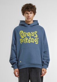Hanorac din bumbac albastru, cu un design grafic texturat galben pe față, buzunar tip kangaroo și mâneci cu tiv ribatat.