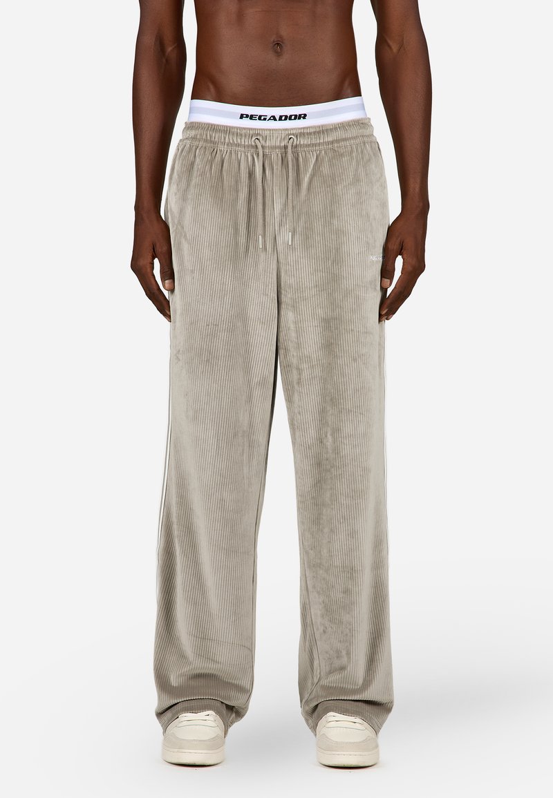 Graue Cordhose mit lässiger Passform, ausgestattet mit einem elastischen Bund mit Logo, Fronttaschen und einer glatten Textur.