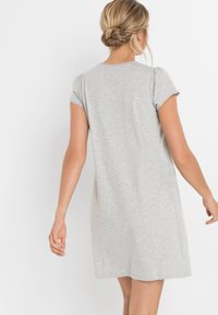 Abito corto grigio a maniche corte con una vestibilità comoda e scollatura rotonda. Realizzato in tessuto morbido e leggero, presenta un design semplice e senza adornamenti.