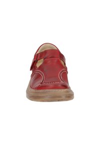 Red leather shoe with open sides, adjustable strap, and white stitching. Features a textured brown sole for grip and support.