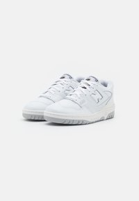 Baskets de sport blanches présentant un dessus en cuir, des accents en mesh, un bout arrondi, une semelle texturée et un logo sur la languette et le côté.